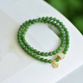 Women's double circle bracelet made of natural Hetian jade featuring a fu character symbol.