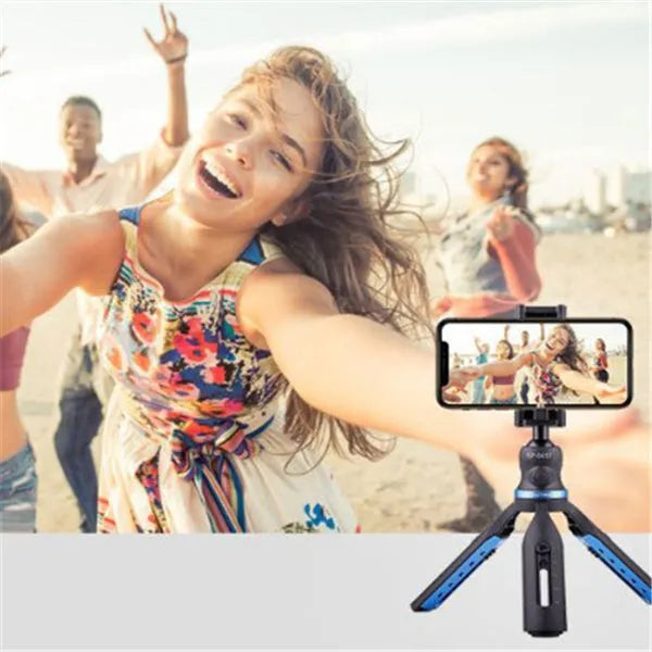 Black desktop tripod stand holding an iPhone X mobile phone.