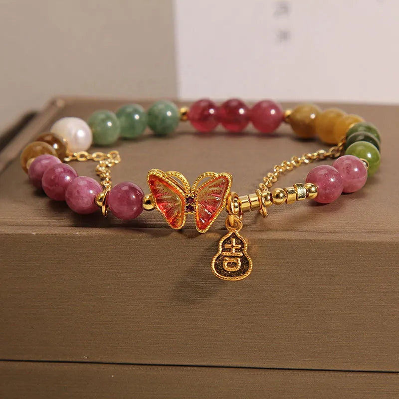 Women's agate and tourmaline bracelet with a detailed butterfly-shaped gourd charm in natural jade colours.