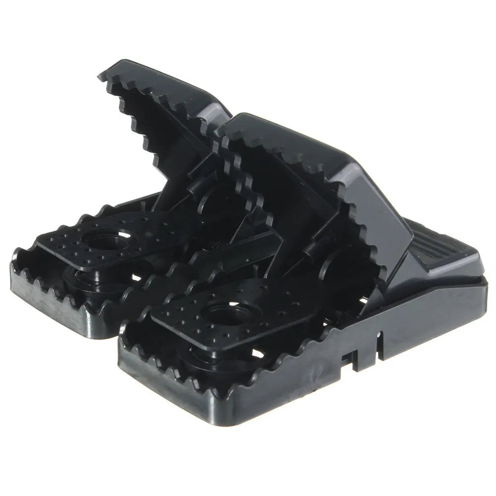 Set of six black plastic snapping mousetraps showing size and smooth surface