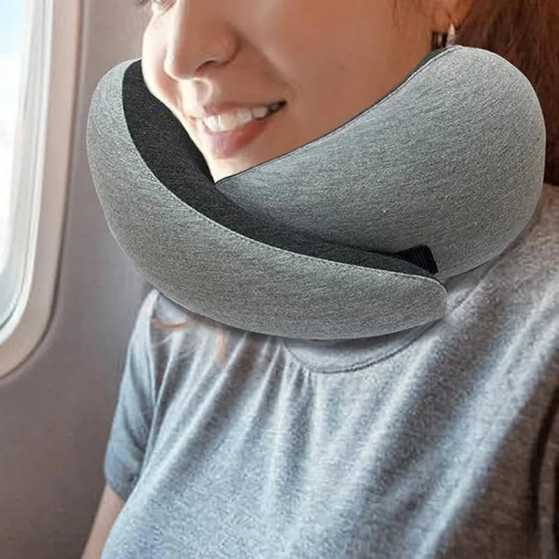 U-shaped navy blue travel neck pillow with memory foam, shown rolled up next to its carry bag.