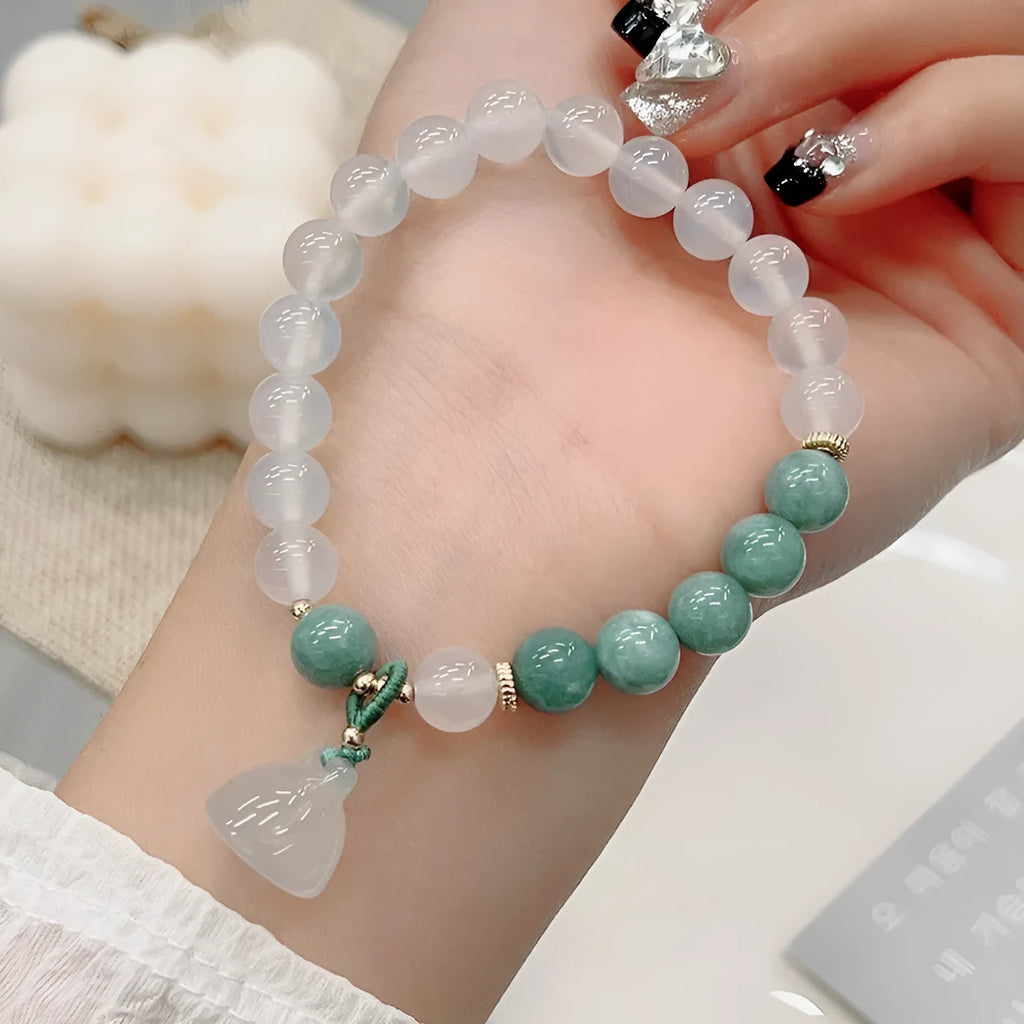 Close-up of a retro-style agate bracelet with a carved lotus seedpod design on a wrist.