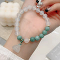 Close-up of a retro-style agate bracelet with a carved lotus seedpod design on a wrist.
