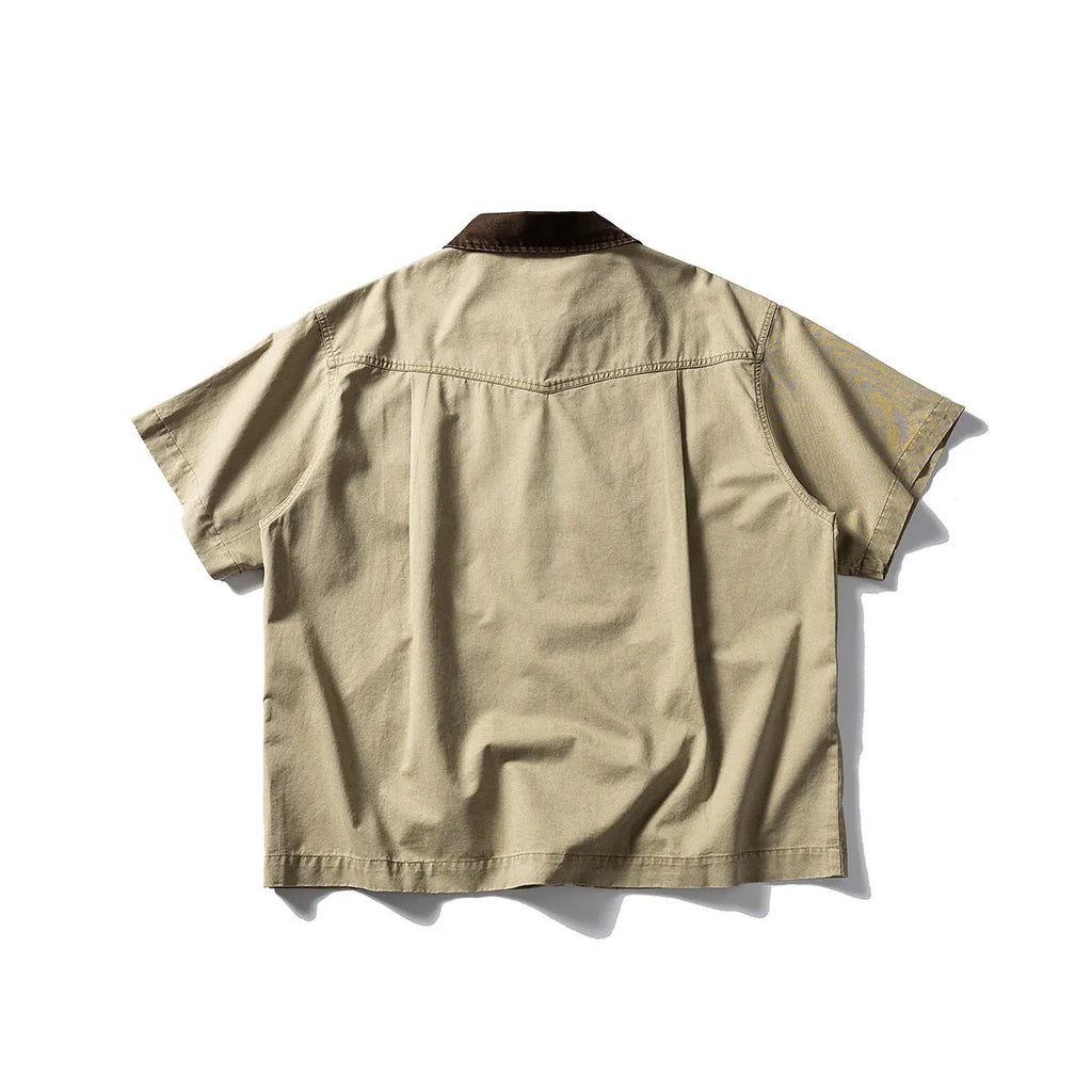 A loose grey or khaki cotton short-sleeved overall shirt, shown as an oversized cardigan style.