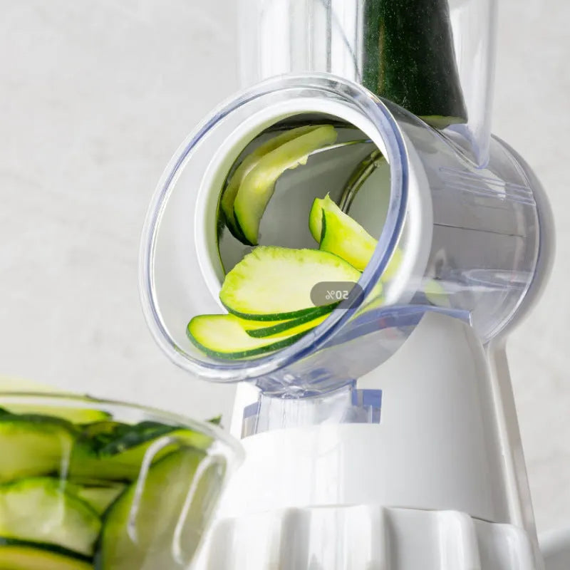 White plastic manual 3-in-1 vegetable slicer grater with stainless steel blades on a kitchen counter.