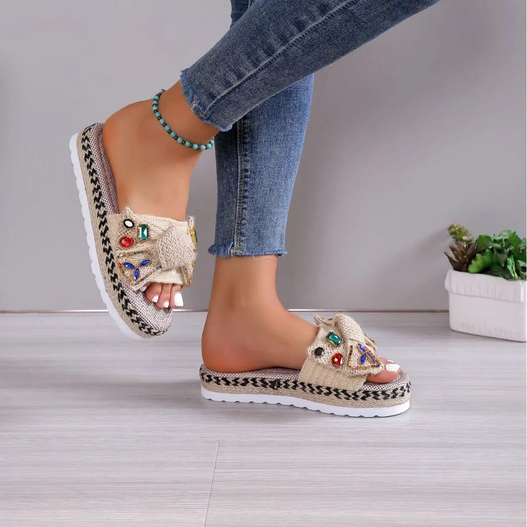 Creamy-white women's platform sandals with beach bow style and cloth construction on model foot