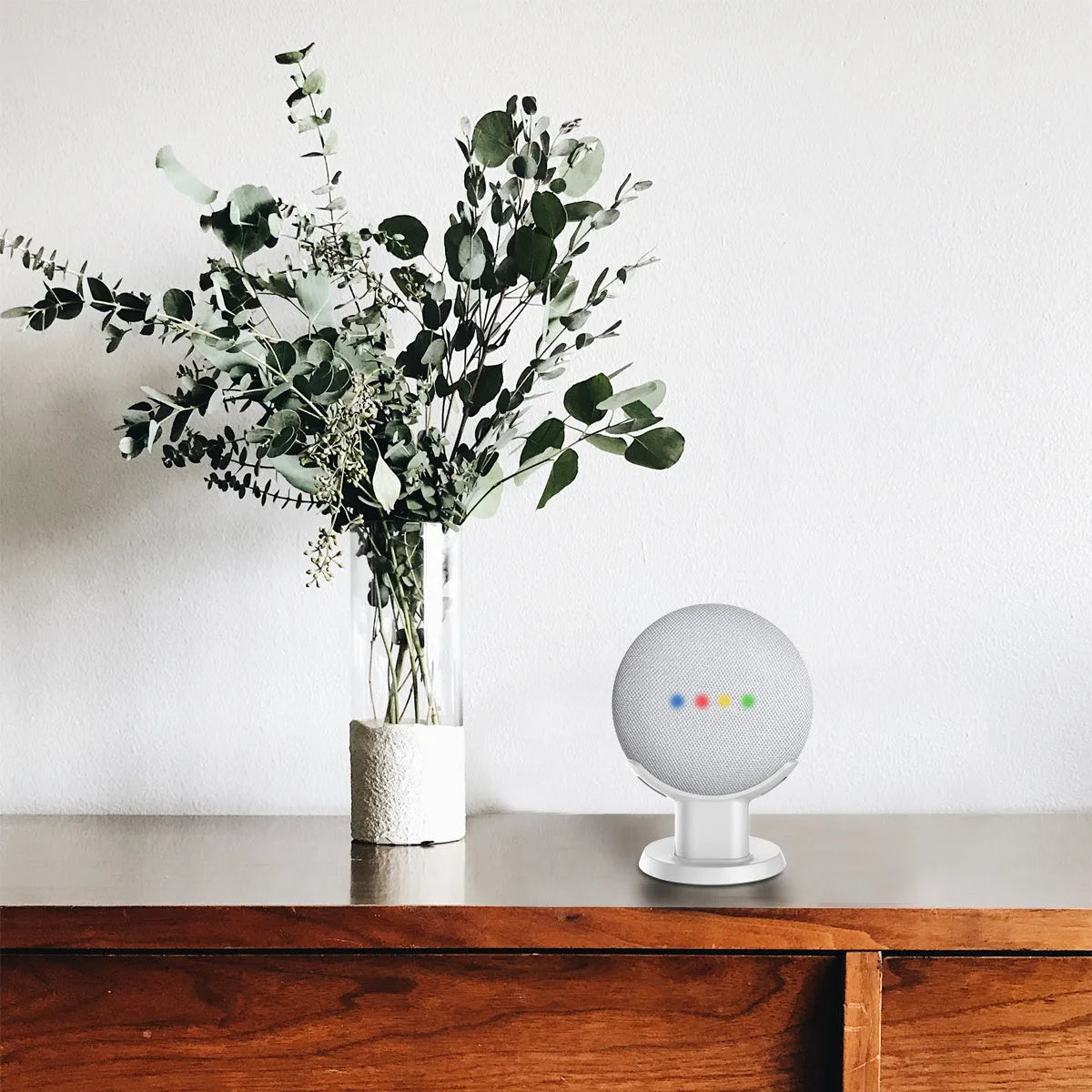 Black plastic Google Home Mini stand holder on a wooden desk