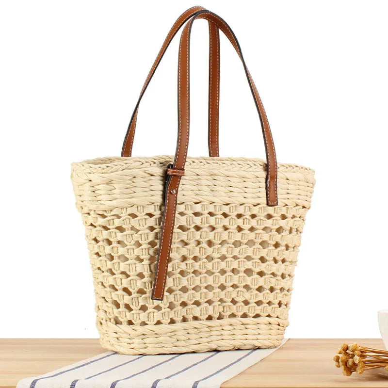 Beige paper-string woven shoulder bag with adjustable strap showing horizontal square design and straw elements