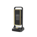 Compact black PTC ceramic desktop air heater with control knob on a wooden desk.