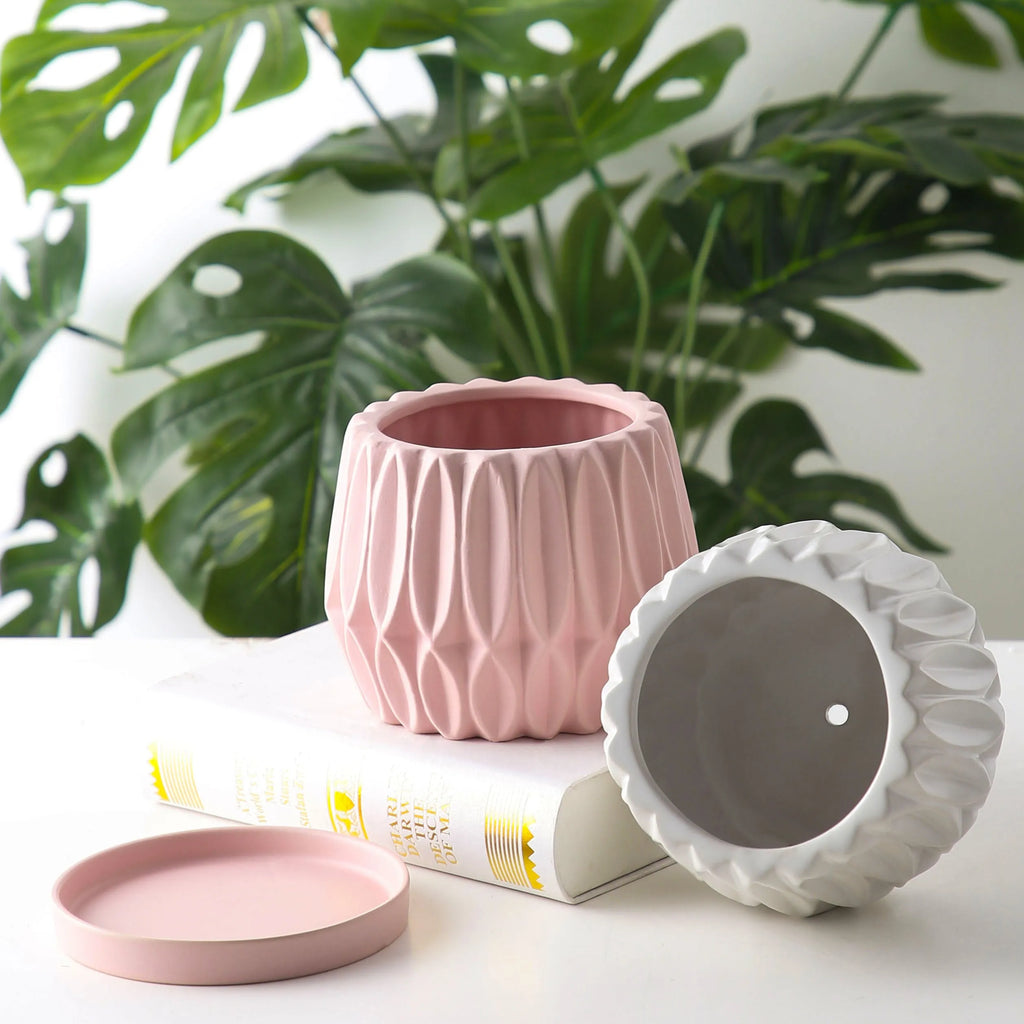 A simple grey ceramic flowerpot, medium-sized, for tabletop or floor plants.