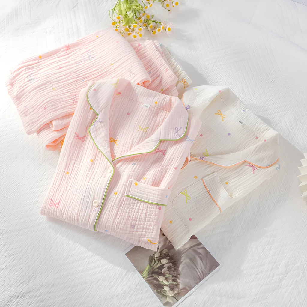 Women's pink cotton pajama set with long sleeves and full-length trousers on hanger