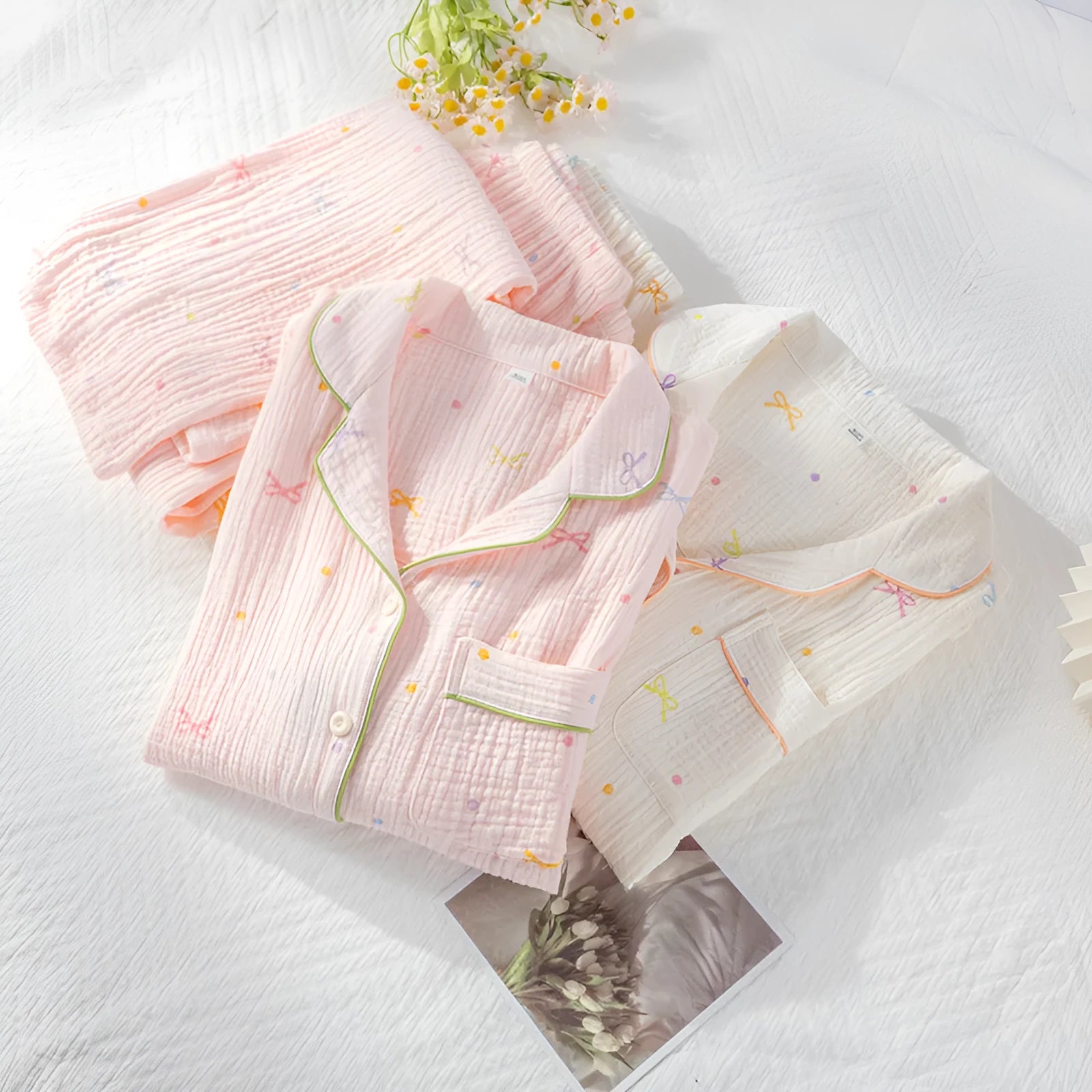 Women's pink cotton pajama set with long sleeves and full-length trousers on hanger