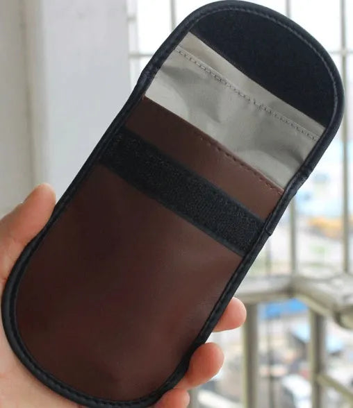 Black microfiber Faraday pouch for blocking car key and credit card signals, shown with a key fob inside.