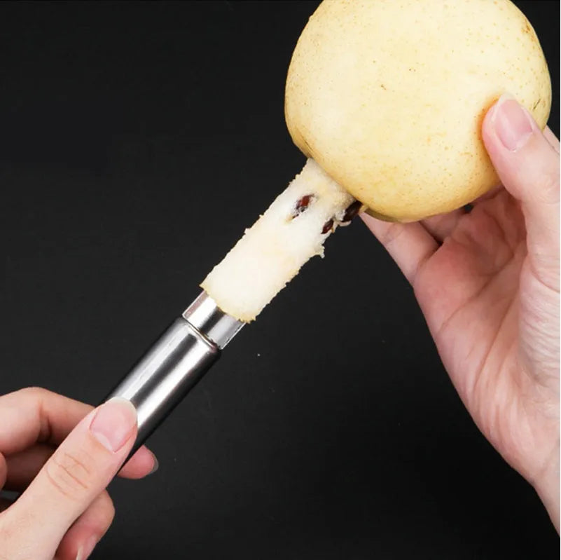 Stainless steel pineapple corer slicer with coloured plastic handle on a kitchen worktop.
