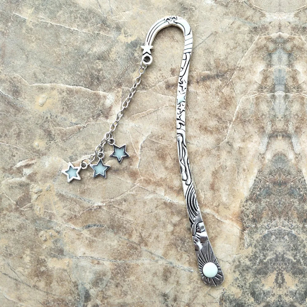Retro five-pointed star metal bookmark glowing with celestial sun moon stars design