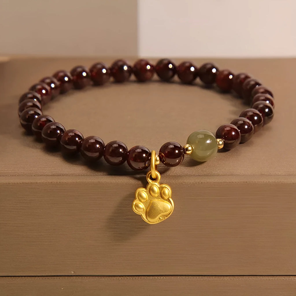 Women's adjustable crystal bracelet with a cat's paw shaped garnet stone centrepiece.