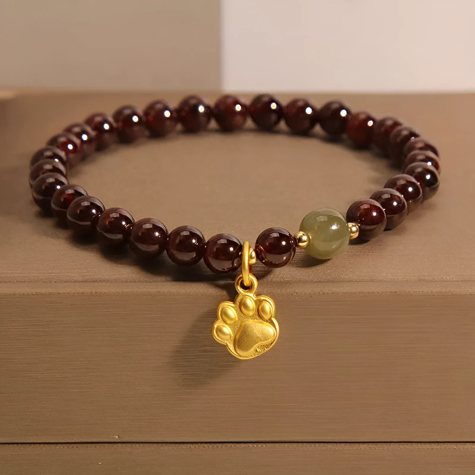 Women's adjustable crystal bracelet with a cat's paw shaped garnet stone centrepiece.