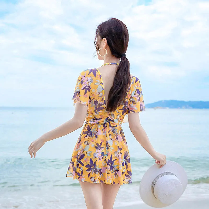 Yellow floral print women's one-piece swimsuit showing front design and polyester fabric construction