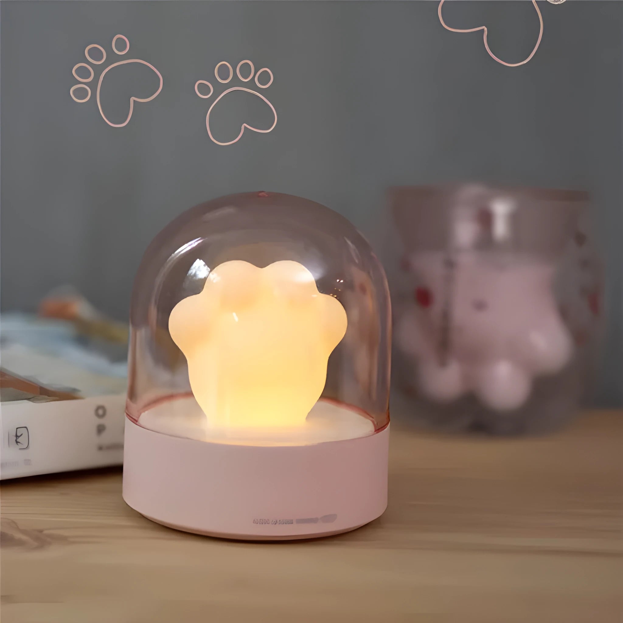 Cute grey or pink cat paw shaped USB rechargeable night light with music box on a desk.
