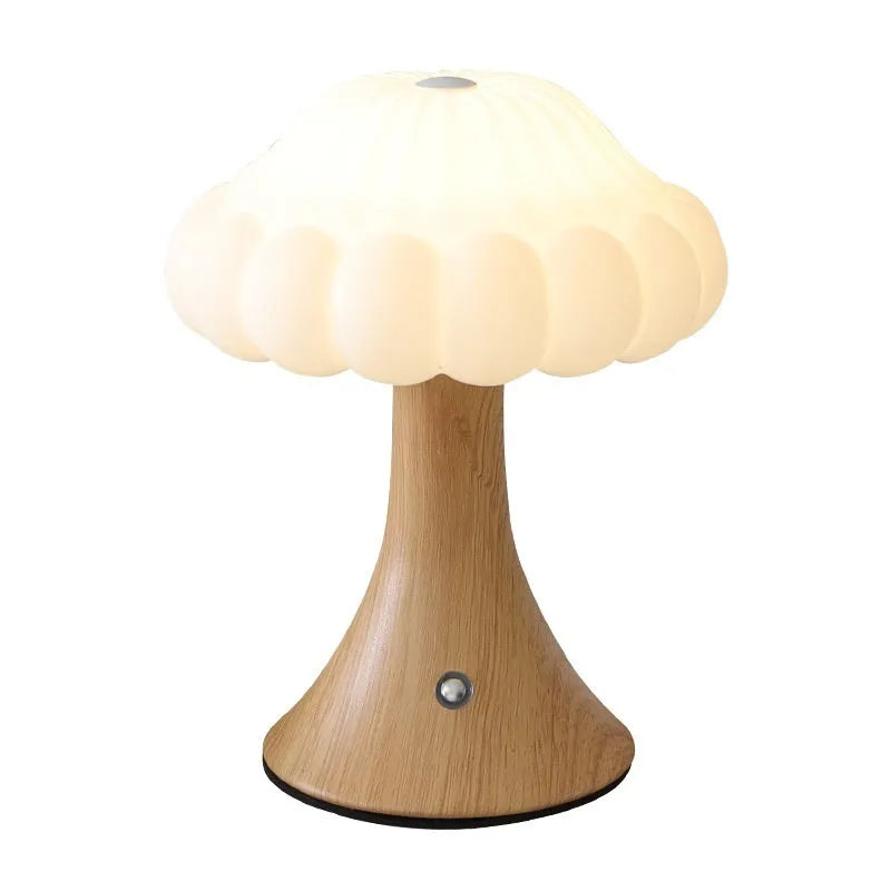 Touch control mushroom night light in wood grain colour on its wireless charging pad.