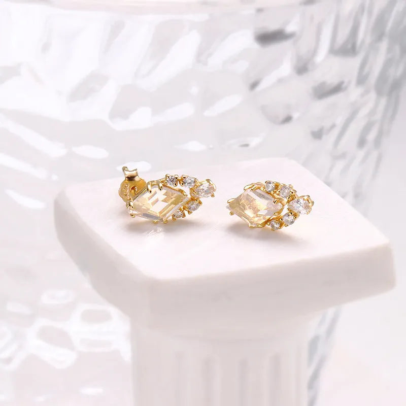 Geometric sterling silver earrings with sweet white crystal studs on white background