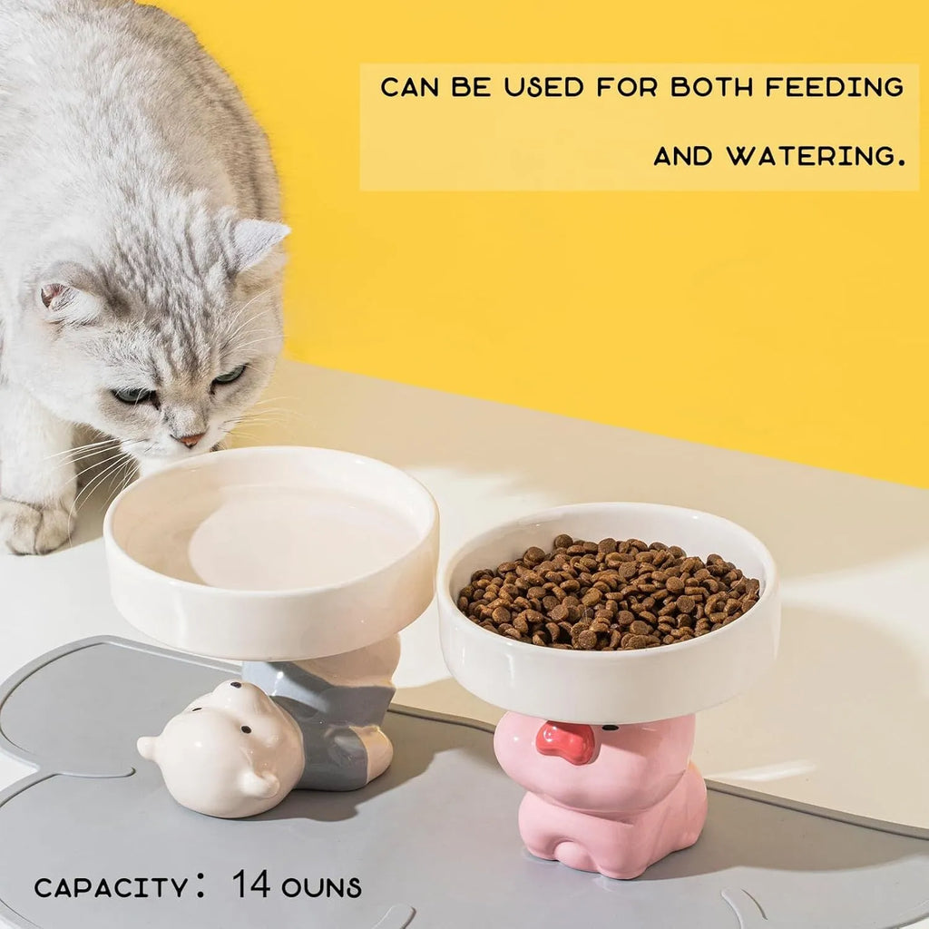White ceramic raised cat bowl with a bear design, showing its elevated stand and wide feeding dish.
