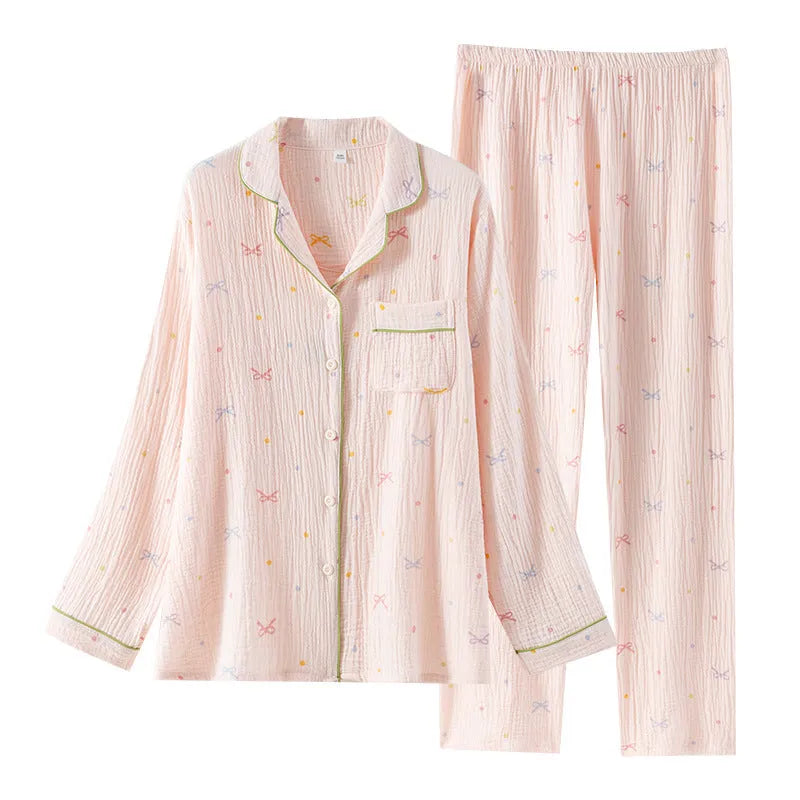 Women's pink cotton pajama set with long sleeves and full-length trousers on hanger