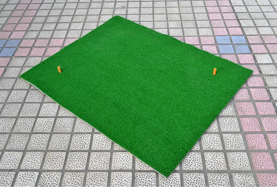Black and green golf practice net tent set up on grass with fibreglass poles and target sheet