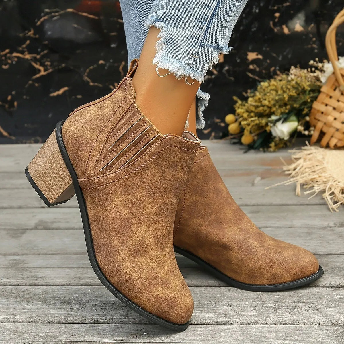 Women's black pointed toe ankle boots with thick square low heel on wooden floor