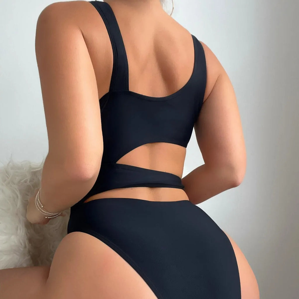 Black hollow high cut one-piece swimsuit on hanger showing sleeveless design