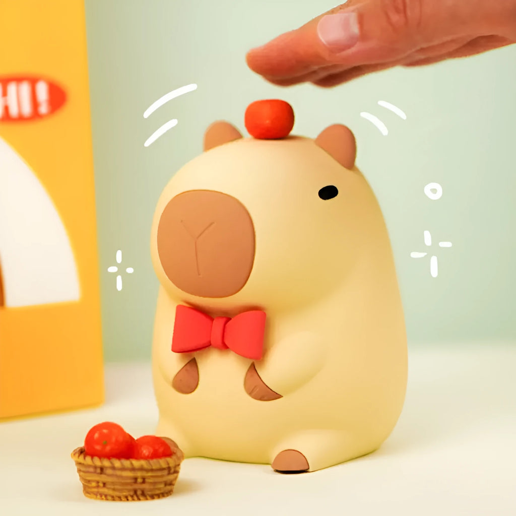Small grey capybara-shaped silicone night lamp on a table.