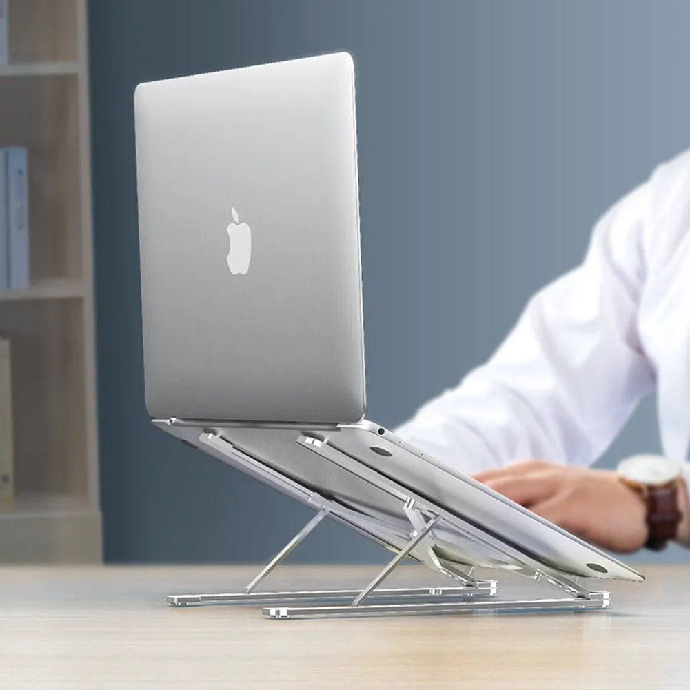 Foldable aluminium laptop stand in silver, shown supporting a laptop at an angle.