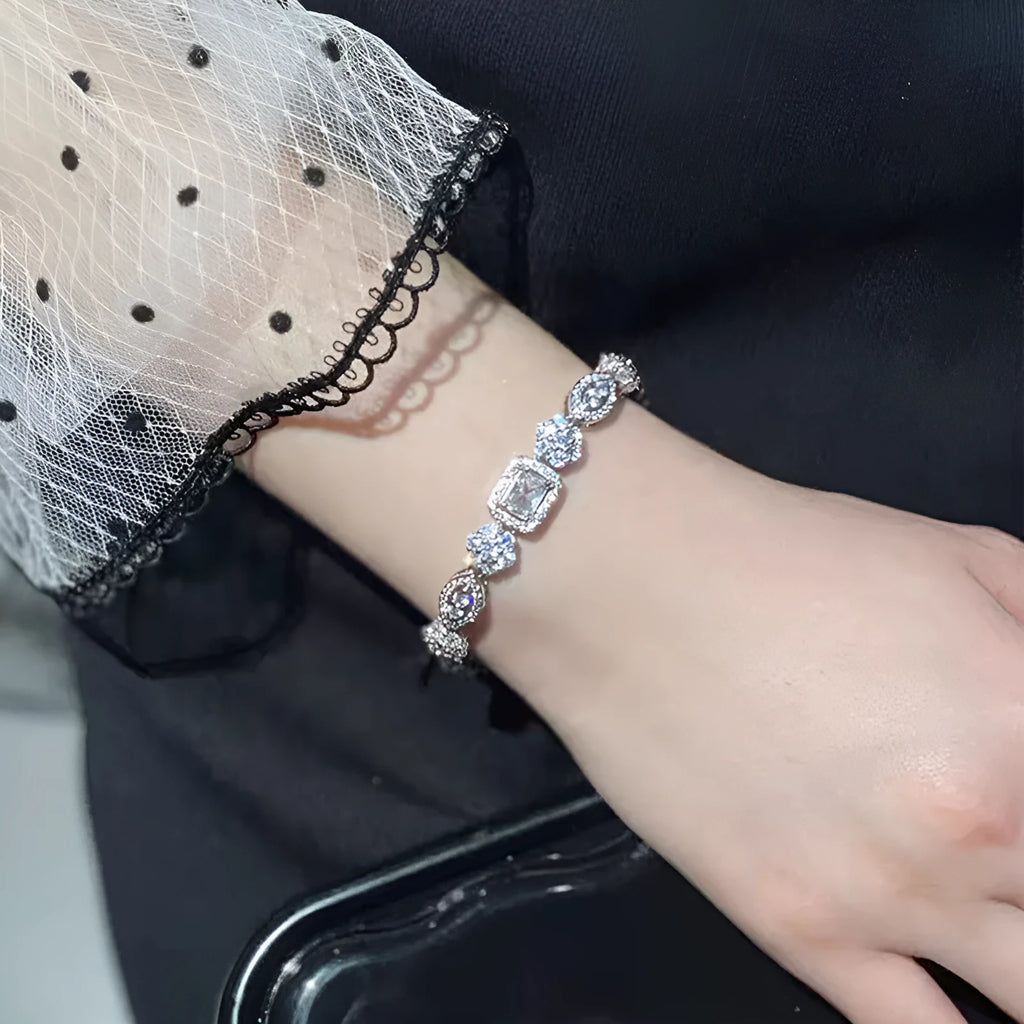 Women's silver-toned geometry bracelet with inlaid clear stones on a model's wrist.