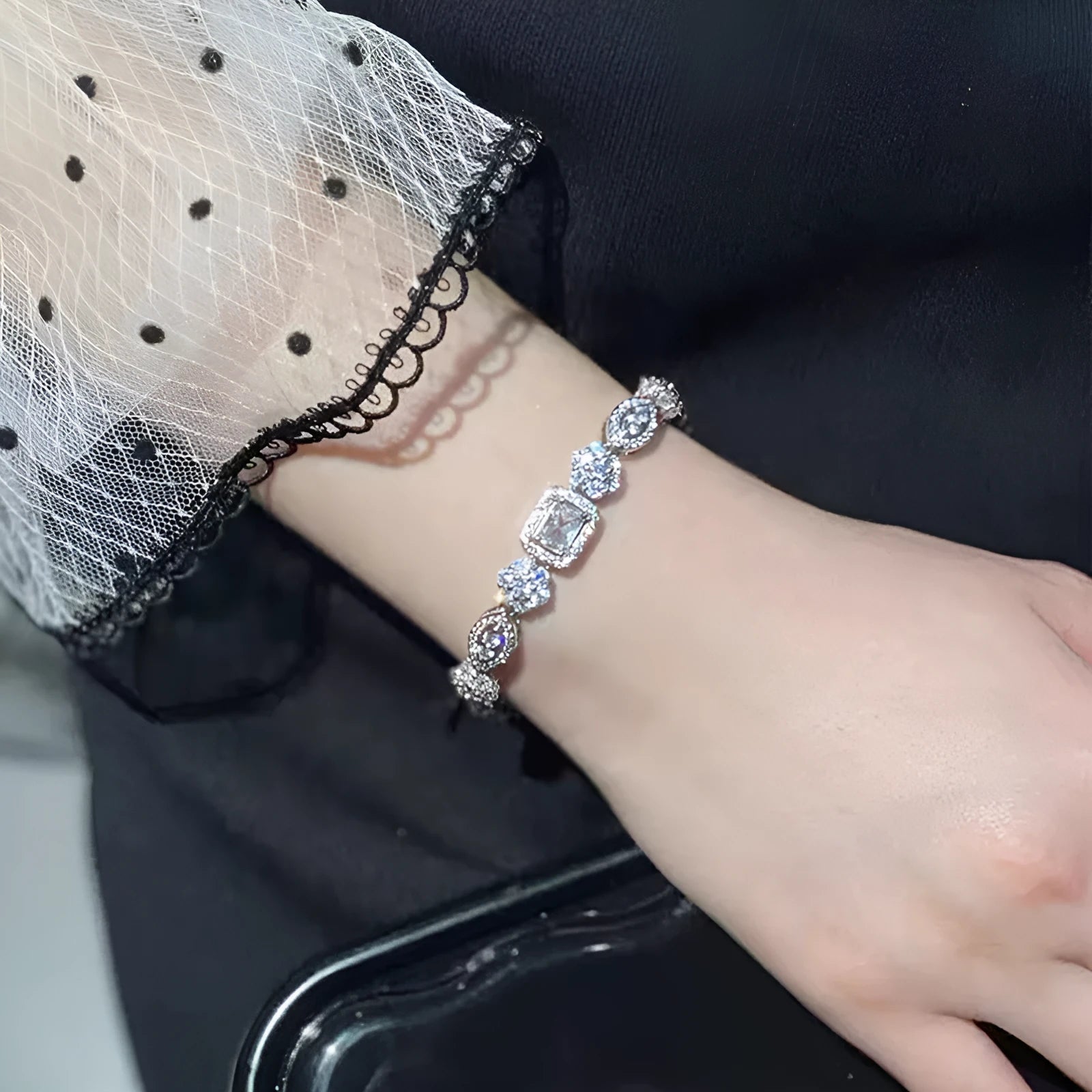 Women's silver-toned geometry bracelet with inlaid clear stones on a model's wrist.