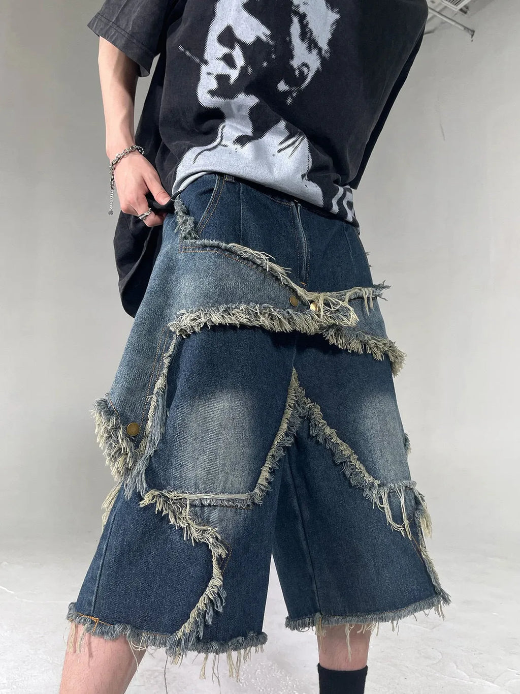 Blue men's denim shorts with a loose fit, frayed hem, and an embroidered five-pointed star on the leg.