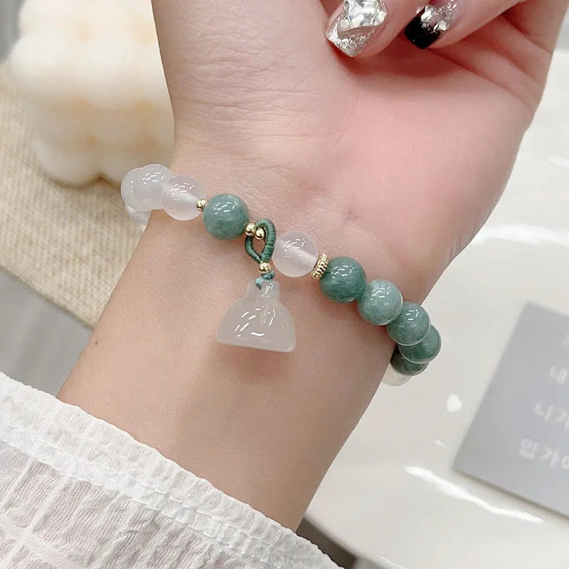 Close-up of a retro-style agate bracelet with a carved lotus seedpod design on a wrist.