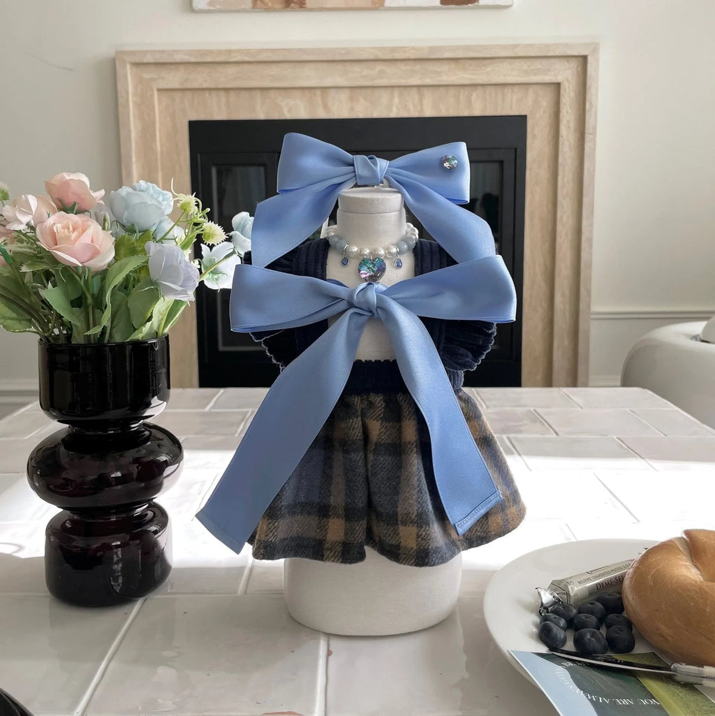 Princess style blue bow dog hair band with adjustable fit on a small dog.