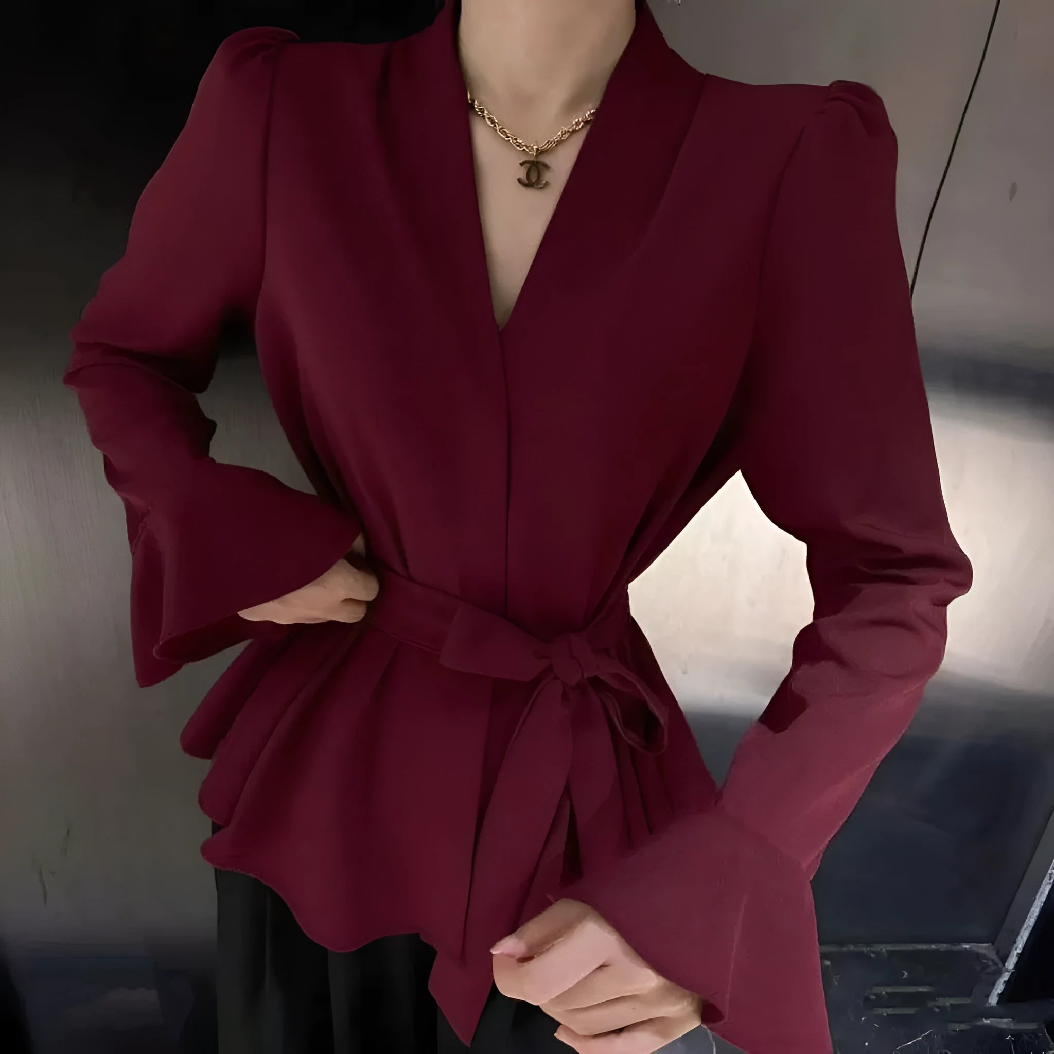 Women's black French-style shirt with an irregular collar and long bell sleeves.