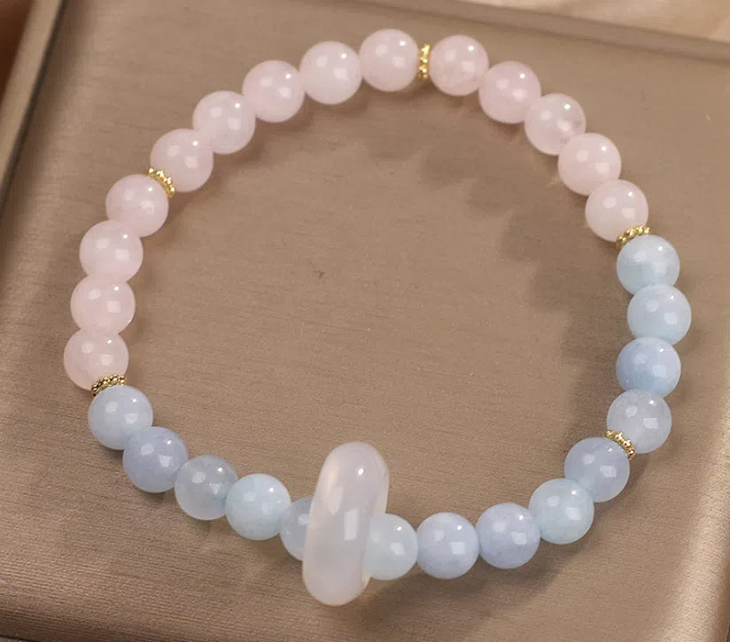 Natural aquamarine crystal beaded bracelet with pink electroplated finish on display