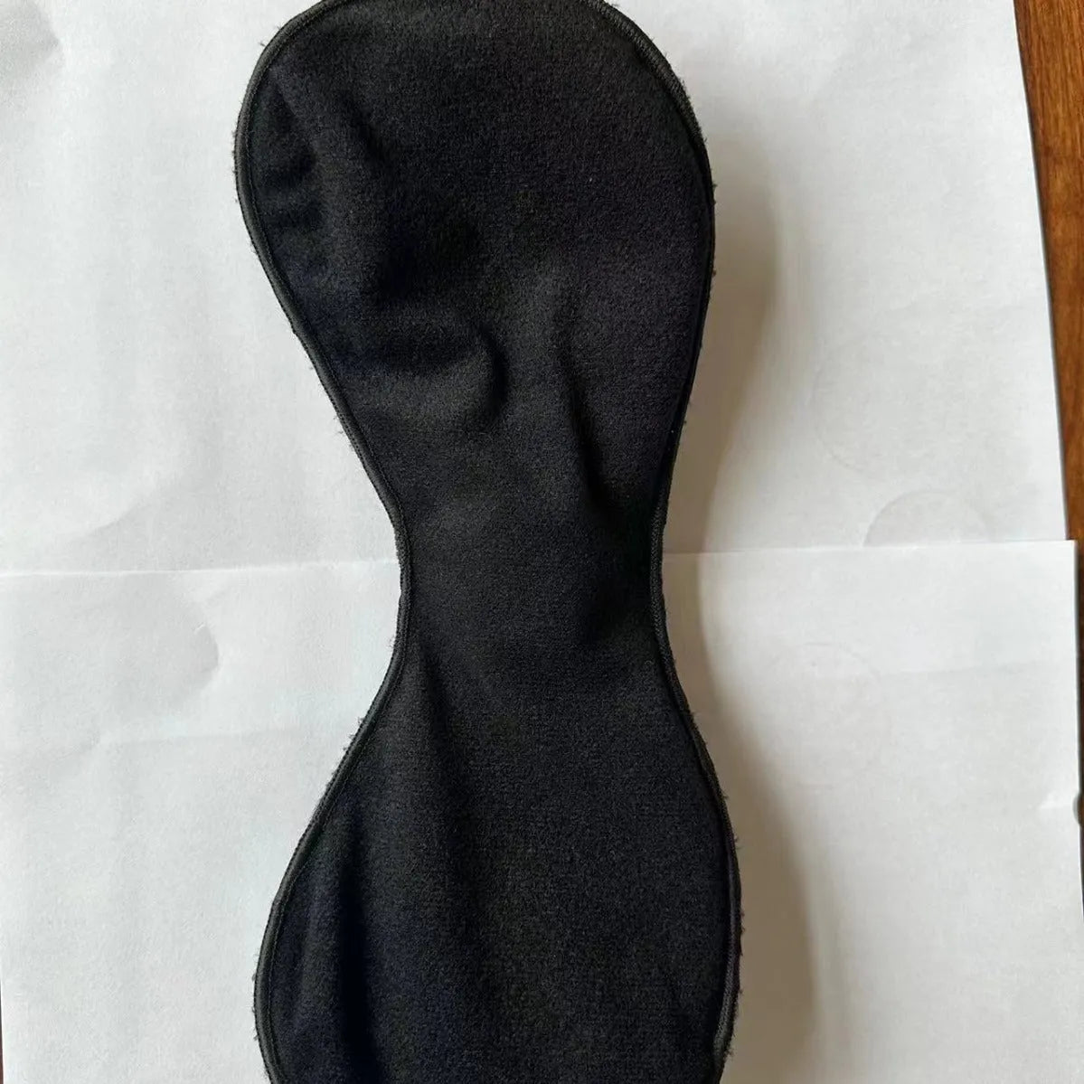 Black adhesive electric chest massage pads with three-key English control unit for hands-free vibration massage.