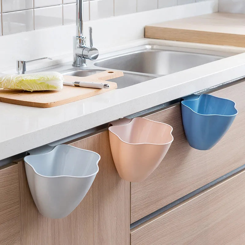 Compact pedal-operated kitchen bin in Nordic blue colour placed inside a wooden cabinet.