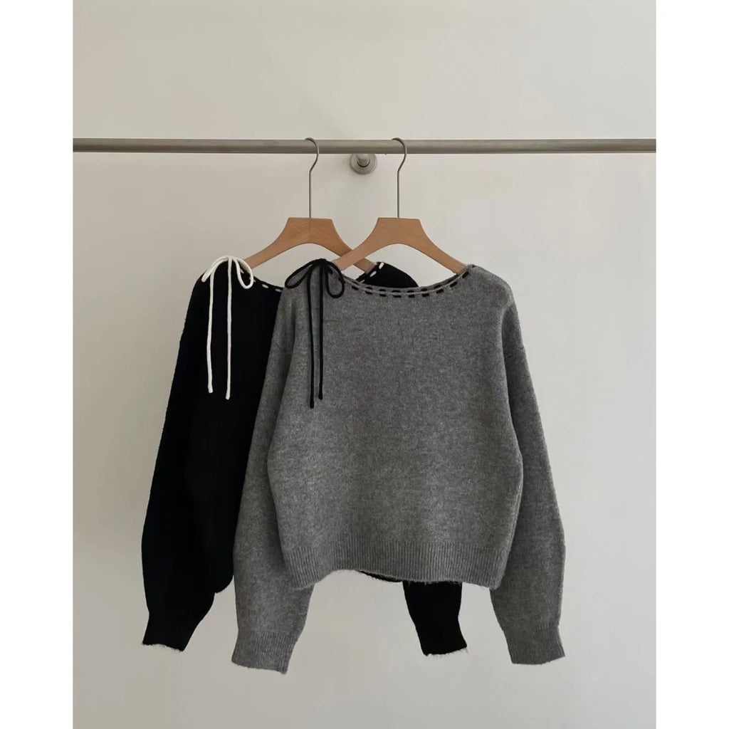 Grey loose-fit women's knit pullover top on a hanger.