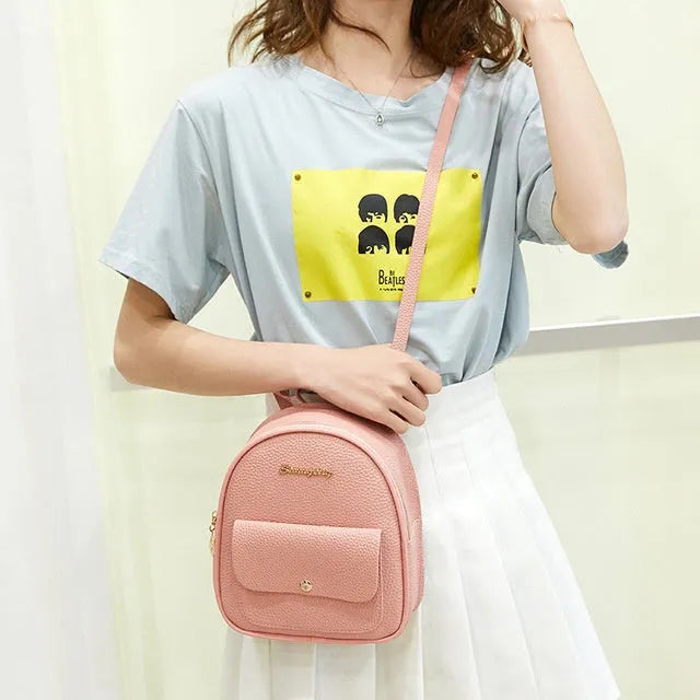 Black PU leather small women's backpack with zipper, shown as a shoulder bag.