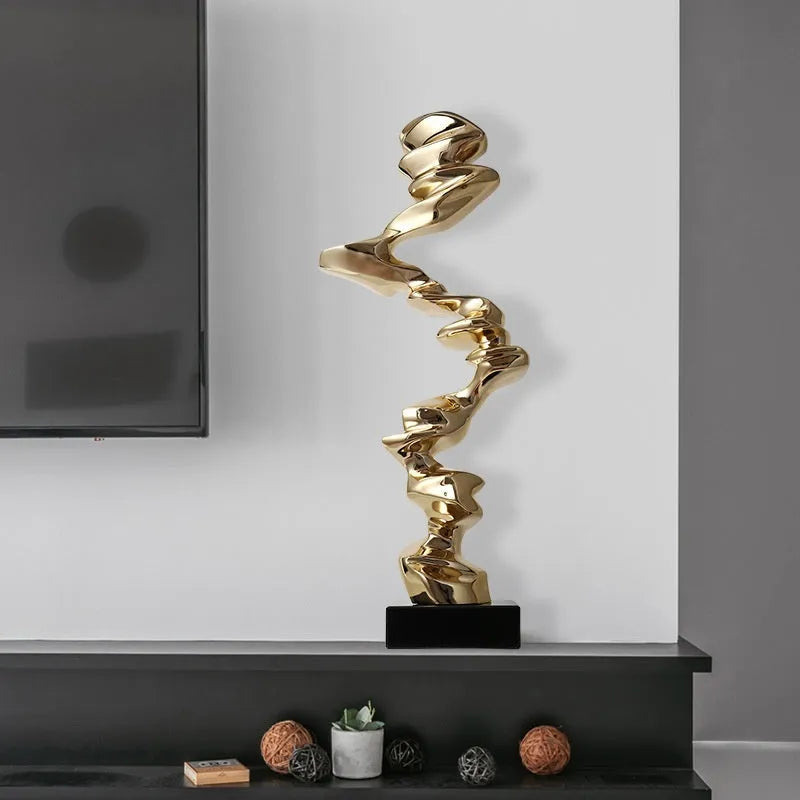 Minimalist abstract still life ornament in natural resin on a shelf, shown in bright gold finish.