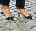Apricot and black women's stiletto sandals with a pointed toe and buckle fastening on a white background.