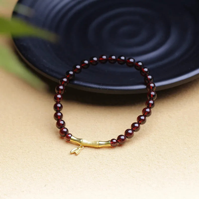 Natural garnet stone set in a 6mm wide bamboo joint bracelet with copper or silver metal finish.