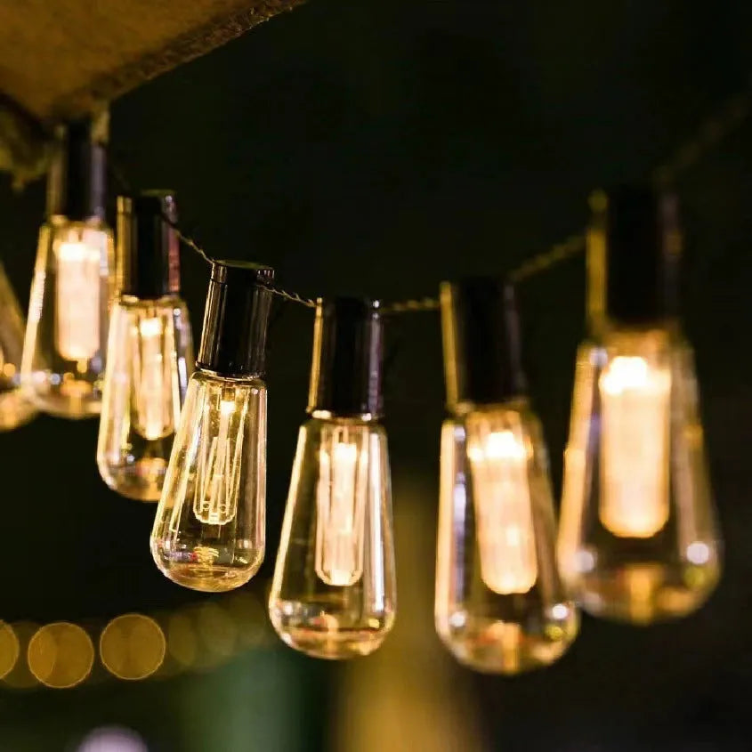 Waterproof outdoor string lights with retro long bulb bottle shape in garden setting