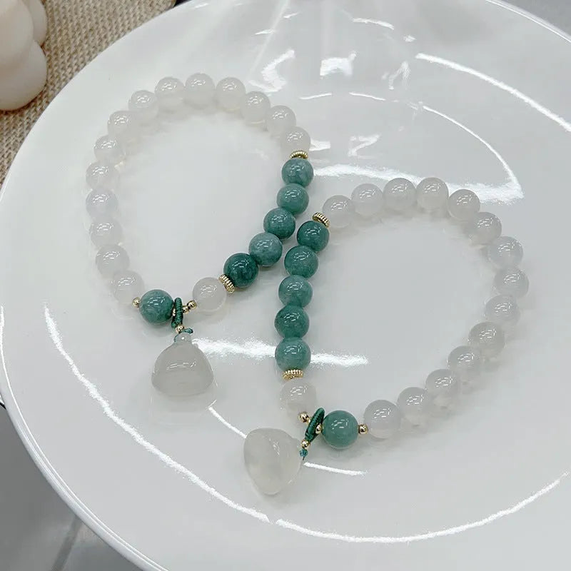 Close-up of a retro-style agate bracelet with a carved lotus seedpod design on a wrist.