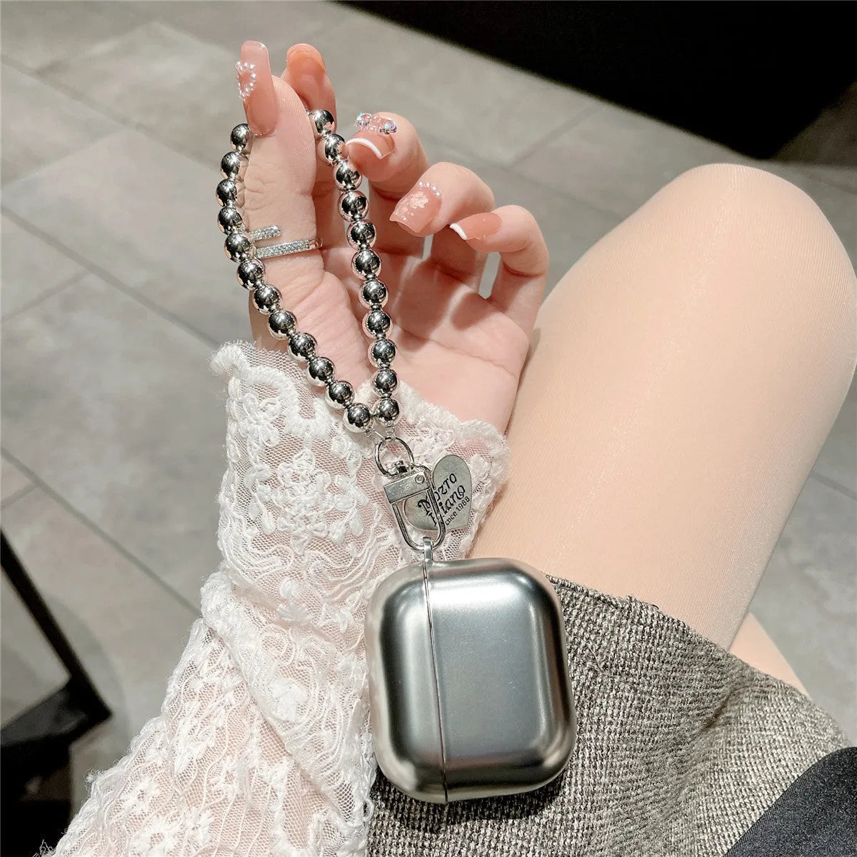 Matte plating TPU protective cover for Apple AirPods with an integrated carrying bracelet attached.