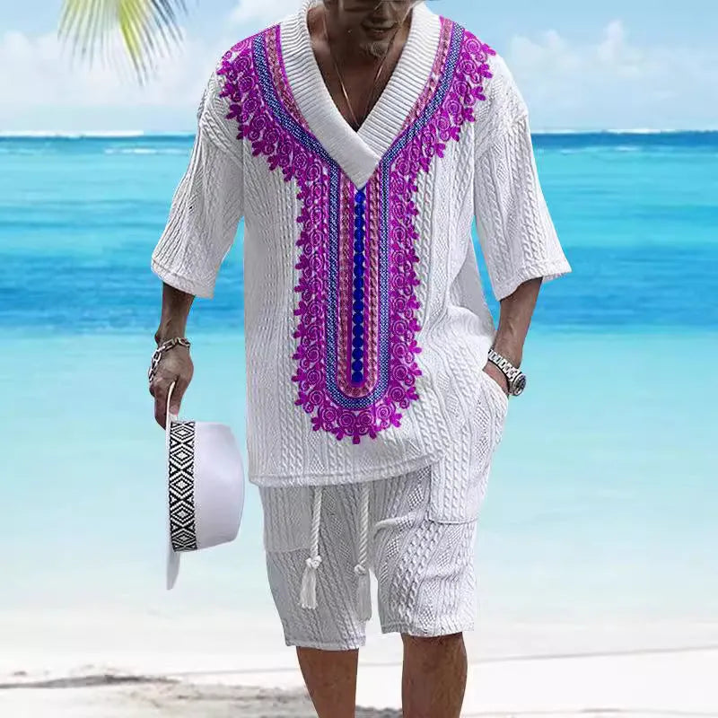 A man wearing a printed drop-shoulder knitted top and matching shorts from a casual two-piece loungewear set.